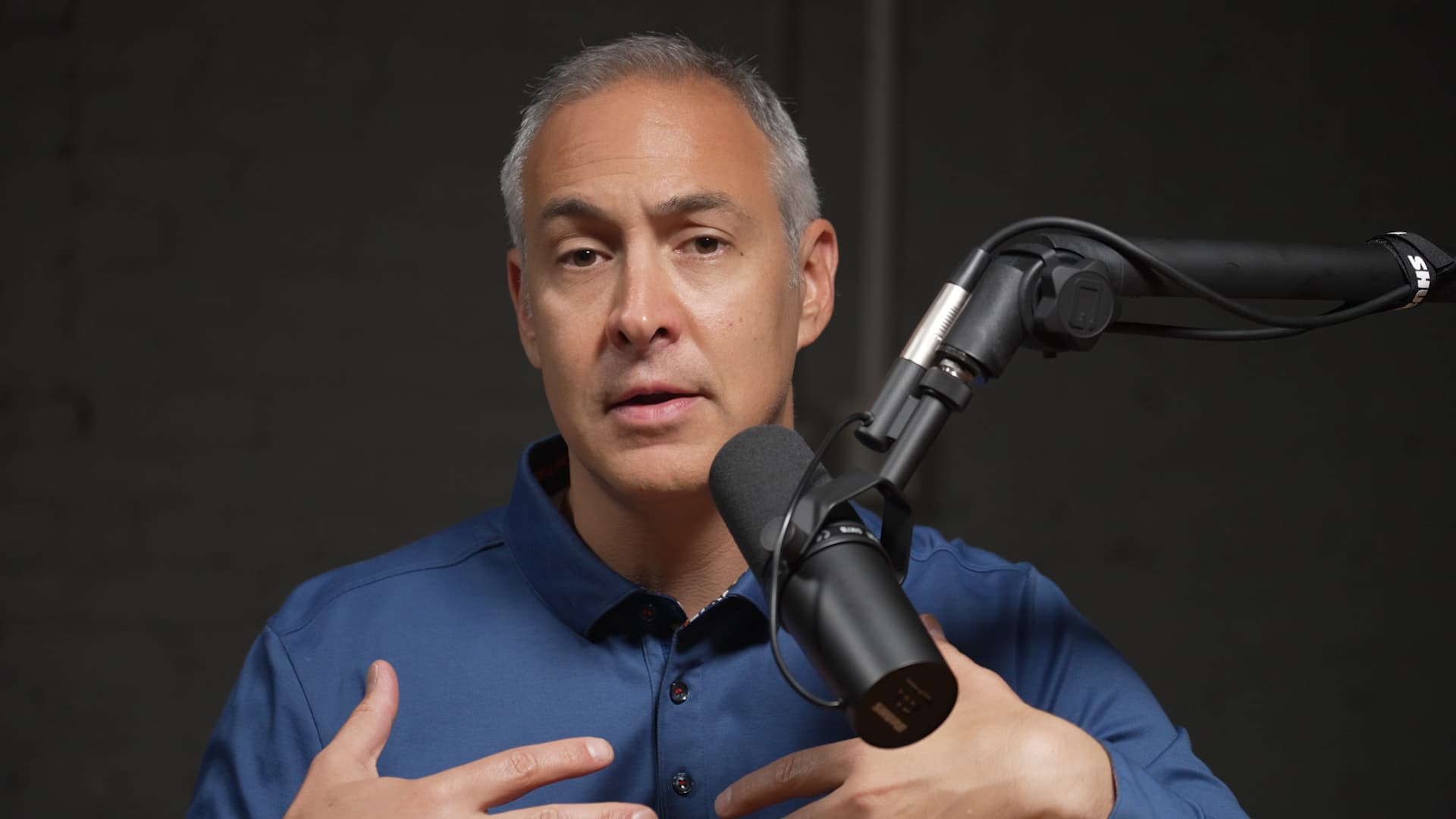 Tony Pisani facing forward while recording a podcast episode with a microphone.